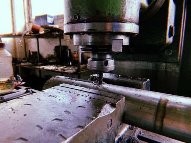Close-up of CNC machine drilling into cylindrical metal workpie