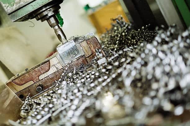 Metal shavings during CNC drilling operation showing material removal in action