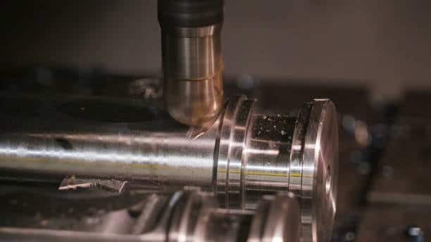 CNC end mill machining parallel grooves on cylindrical metal shaft