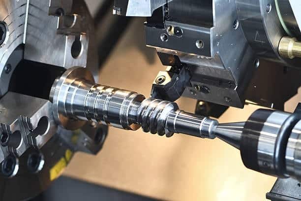 CNC lathe cutting a complex threaded screw part with high precision