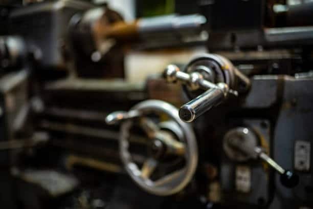 Close-up of CNC lathe machine handwheel and control panel for screw machining