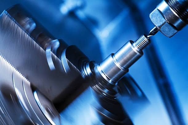 CNC lathe cutting tool shaping a rotating metal component in high-speed operation