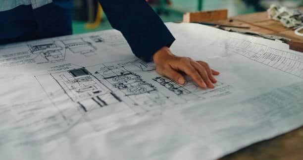 Engineer reviewing CNC machine blueprints for custom part design