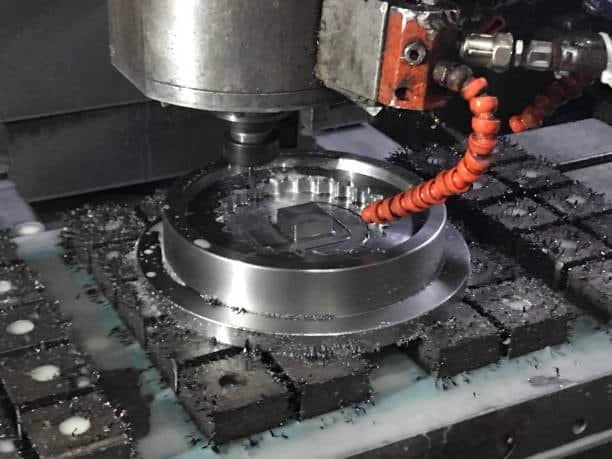 Close-up of CNC machine cutting a round metal component during automated machining
