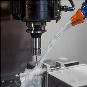 CNC machine cutting a mold component with coolant spray, ensuring precision and maintaining high-quality standards during production.