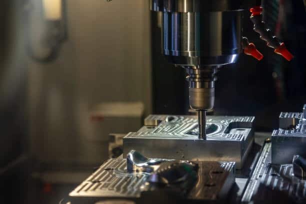 CNC milling machine cutting a metal mold with high-precision end mill