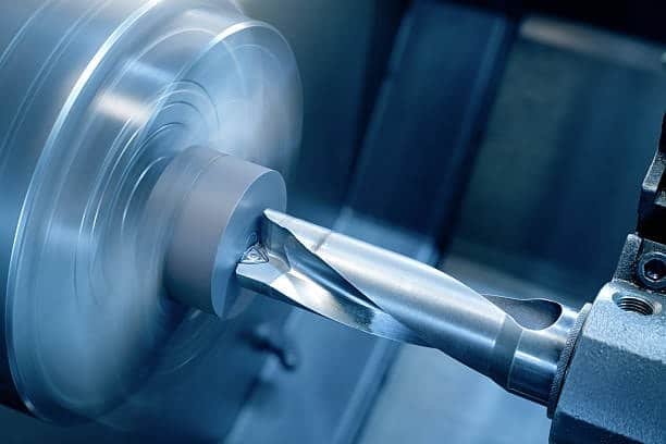 CNC turning process showing a rotating workpiece being cut by a stationary tool