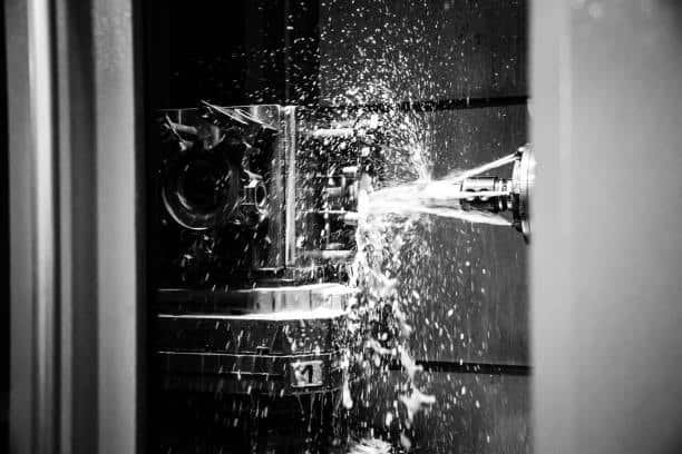 CNC turning center operating with powerful stream of coolant during cutting