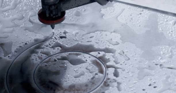 CNC waterjet cutting a circular pattern into a metal sheet