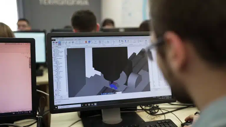 Engineer using CAE software to simulate part machining process