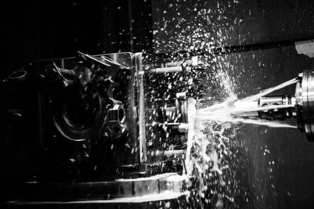 Custom metal part being cut on CNC machine with high-pressure coolant