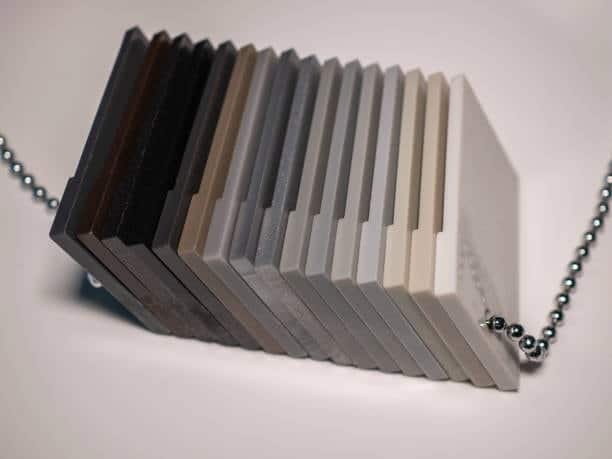 Various shades of Delrin plastic chips showcasing POM-C and POM-H material options