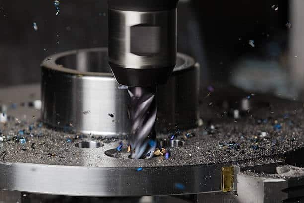 Drill bit milling a circular hole into steel part