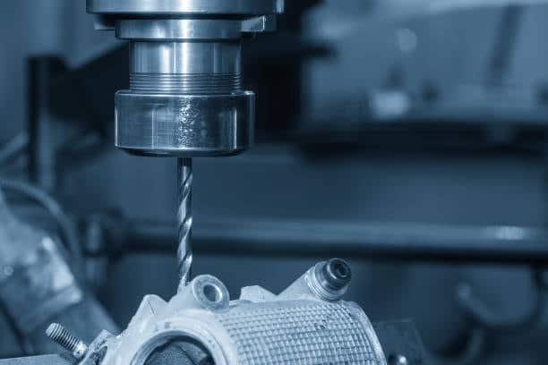 Drill bit operating on aluminum workpiece in dry machining setup without fluid