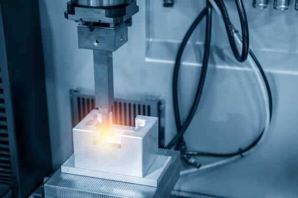 EDM electrode machining metal with visible spark in tool and die application