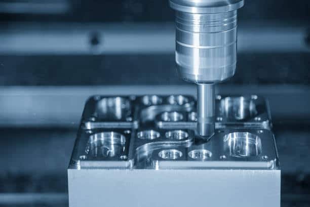 End mill machining a metal block on a CNC milling center
