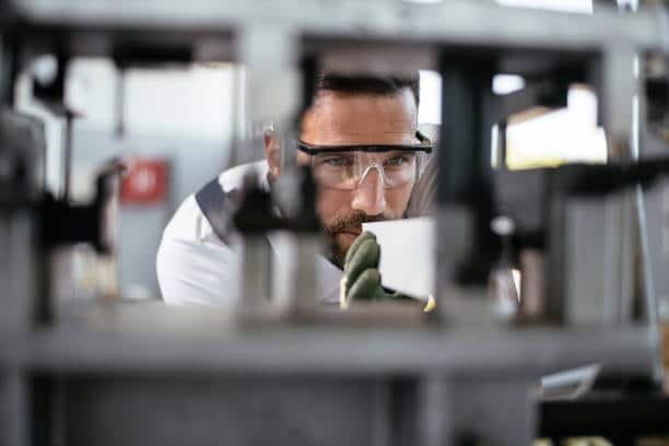 Quality control engineer inspecting internal fixture alignment during part validation process in a precision workshop