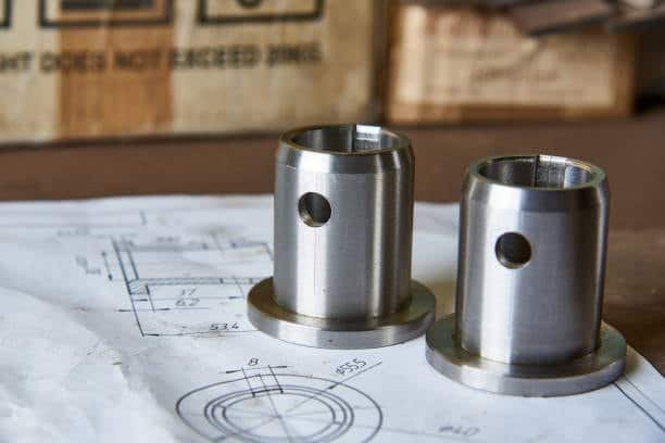 Machined metal components placed over a technical tolerance drawing