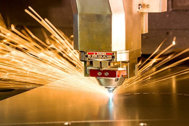 High-power fiber laser cutting machine emitting sparks while cutting metal shee