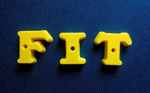 The word FIT shown using plastic alphabet letters for tolerance illustration