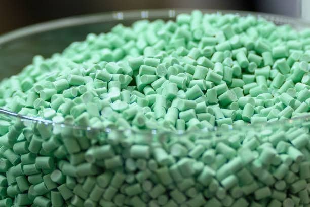 Close-up of green plastic pellets used in custom injection molding production