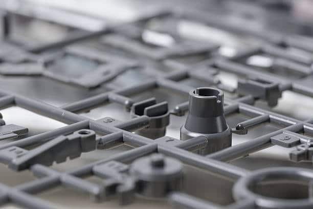 Glossy gray injection molded components still attached to sprue frame
