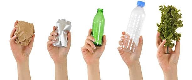 Five hands holding recyclable materials like paper, metal can, glass bottle, plastic bottle, and a plant