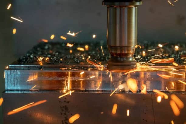 CNC cutting operation with green sparks illustrating optimal cutting speed and feed rate