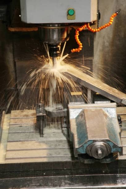 High-speed CNC milling machine creating sparks during heavy metal cutting