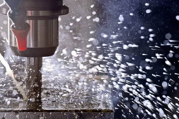 CNC milling tool cutting metal with coolant fluid spraying for temperature control