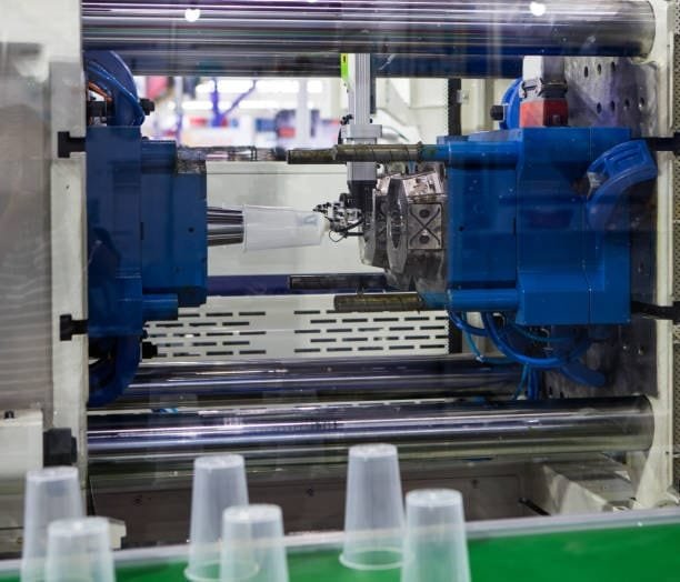 Injection molding machine creating low-cost plastic cups.