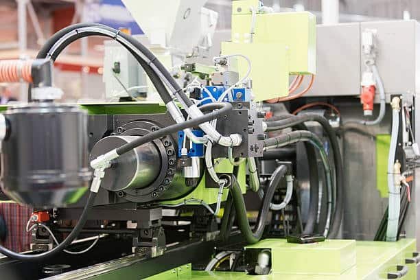 Close-up of injection molding machine reducing mold production costs.