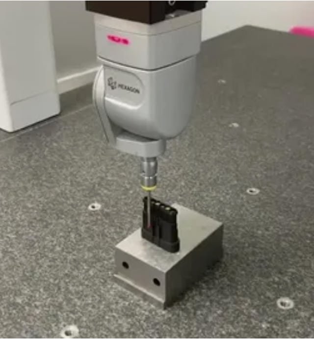 CMM probe inspecting a precision-molded component on a granite measurement table, ensuring dimensional accuracy and quality control.