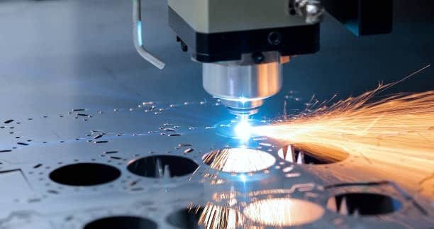 High-speed laser cutting operation on metal sheet with sparks flying