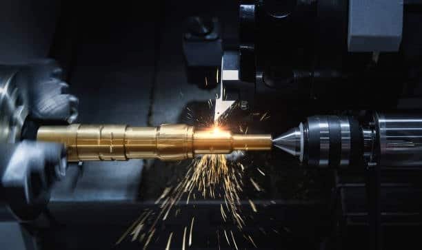 5-axis CNC machine drilling a complex metal component with sparks