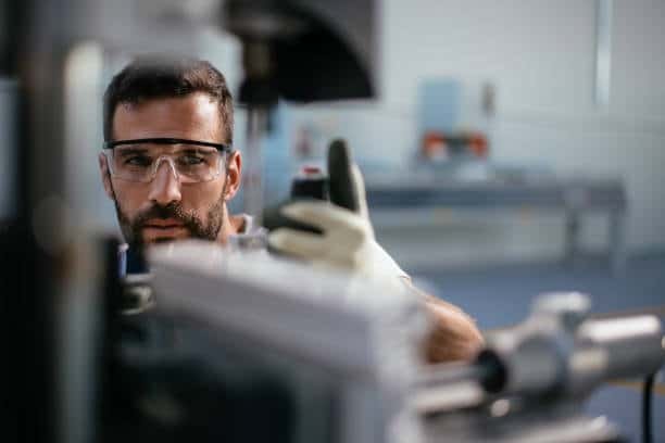 Focused technician visually inspecting measurement accuracy using calibrated inspection equipment