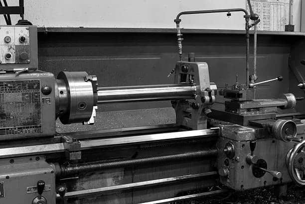 Industrial lathe machine setup for turning a long cylindrical metal part