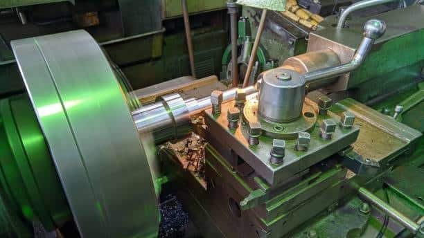 Precision manual lathe turning a polished metal shaft