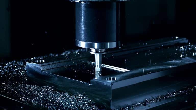 CNC milling machine cutting a metal block