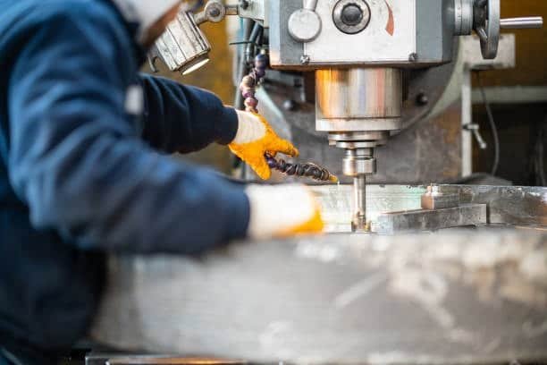 Operator working with a vertical milling machine in a workshop