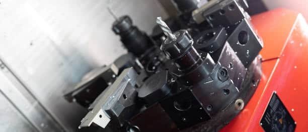 Close-up of multi-axis CNC turret tool head with mounted drill bit