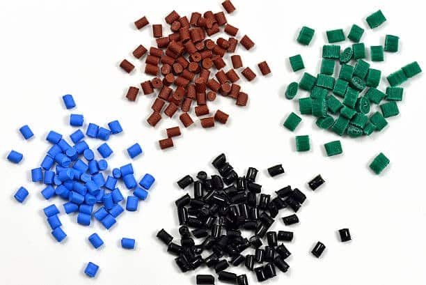 Blue, red, black, and green ASA plastic pellets for molding.