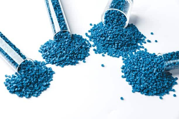 Blue TPE pellets spilled from four glass tubes, illustrating batch testing for non-toxic material verification.