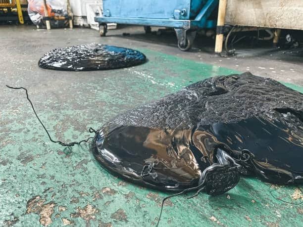 Overheated plastic material melted and pooled on factory floor