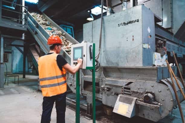Worker operating temperature-controlled plastic recycling line in a factory