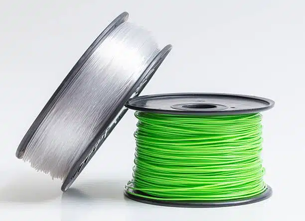 Comparison of translucent polycarbonate and green polypropylene filament spools.