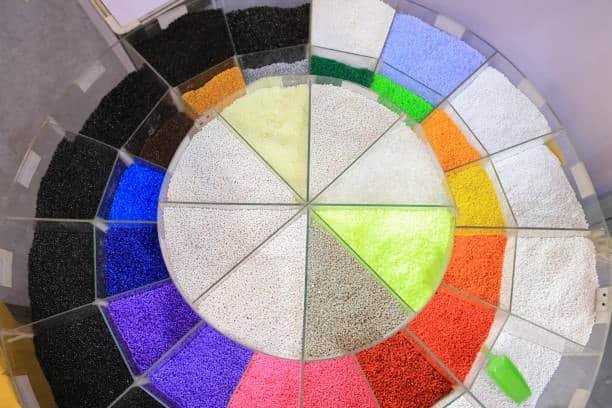 Wide color selection of polypropylene resin granules arranged in a circular display.
