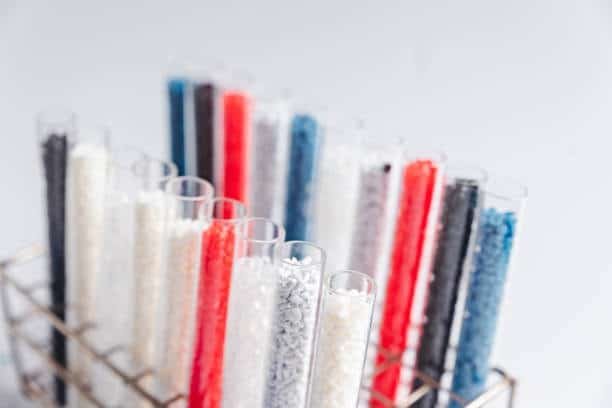 Colorful polypropylene pellets stored in lab test tubes for safety and quality testing.