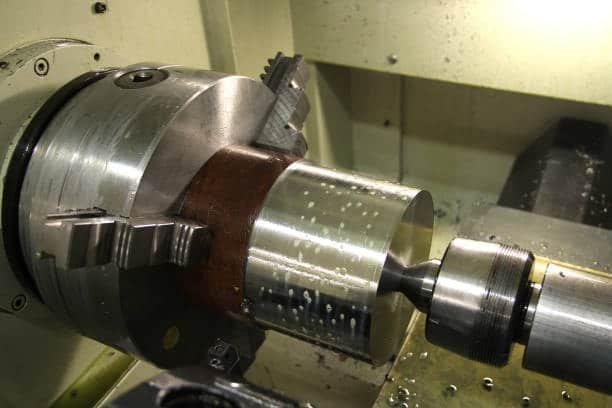 CNC lathe performing internal cutting on a cylindrical metal part