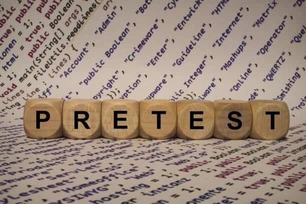 Wooden blocks spelling “PRETEST” over technical terms, symbolizing tolerance verification